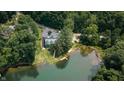 High angle view of a charming home surrounded by dense woods and overlooking a pristine lake at 4126 E Rembrandt Dr, Martinsville, IN 46151