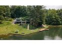 Beautiful lake house with a wooden dock, stone steps, and a well-manicured lawn, nestled by the water at 4126 E Rembrandt Dr, Martinsville, IN 46151