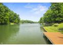 Scenic view of the serene lake surrounded by lush greenery and mature trees on a clear day at 4126 E Rembrandt Dr, Martinsville, IN 46151