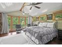 An inviting main bedroom featuring vaulted ceilings, ceiling fans, and serene lake views through large windows at 4126 E Rembrandt Dr, Martinsville, IN 46151