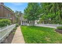 Beautifully landscaped front yard with lush lawn, mature trees, and a charming white picket fence at 4732 N Kenwood Ave, Indianapolis, IN 46208