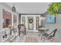 Cozy screened porch with wicker furniture, tile flooring, and serene natural light at 4732 N Kenwood Ave, Indianapolis, IN 46208