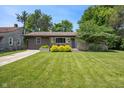 Inviting single-story home with stone and wood facade, lush lawn, and well-maintained landscaping at 4742 Kingsley Dr, Indianapolis, IN 46205