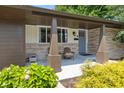 Cozy front porch with stone pillars, seating, and well-manicured landscaping at 4742 Kingsley Dr, Indianapolis, IN 46205