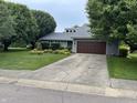 Charming home featuring a well-manicured lawn and an attached two-car garage at 4760 Winterberry Pl, Columbus, IN 47201