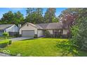 Charming ranch-style home featuring a well-manicured lawn and an attached two-car garage at 5010 Donner Ln, Indianapolis, IN 46268