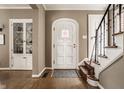 Inviting entryway features hardwood floors, stairs, built-in cabinet, and a decorative front door at 5615 N Pennsylvania St, Indianapolis, IN 46220