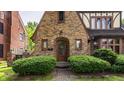A closer view of the entryway, featuring an arched doorway, brick facade, and lush shrubbery at 5615 N Pennsylvania St, Indianapolis, IN 46220