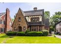 Charming Tudor-style home with brick facade, gabled roof, and well-manicured lawn and shrubbery at 5615 N Pennsylvania St, Indianapolis, IN 46220