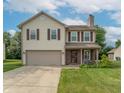 Inviting two-story home with a classic facade, attached garage, and a lovely front yard at 6635 Blackthorn Dr, Indianapolis, IN 46221