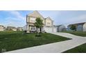 Beautiful home with a lush green lawn, mature tree, and a three car garage at 6842 Arrowhead Dr, Brownsburg, IN 46112