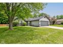Well-manicured front lawn with mature trees compliments this home with a two car garage at 7239 Wet Rock Ct, Indianapolis, IN 46236