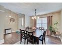 Bright dining room with modern lighting, rich wood floors, and seating for six guests at 7372 Oakview Dr, Avon, IN 46123