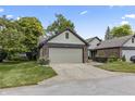 Charming home featuring a two-car garage, beautiful brick accents, and a well-maintained lawn at 7616 Derrek Pl, Indianapolis, IN 46219