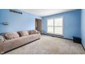 Bright living room with soft blue walls, a large window, and cozy carpeting at 8306 Corkwood Dr, Indianapolis, IN 46227