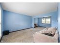 Spacious living room with a sitting area, soft blue walls, and bright natural light at 8306 Corkwood Dr, Indianapolis, IN 46227