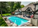 Gorgeous backyard with a swimming pool, hot tub, lounge chairs and an outdoor entertaining area at 8651 Emerald Ln, Indianapolis, IN 46260