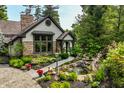 Beautiful backyard with mature trees, lovely landscaping, garden beds and charming water feature at 8651 Emerald Ln, Indianapolis, IN 46260