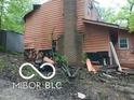 Damaged exterior with chimney, siding issues, and exposed foundation at 8803 S Sleepy Hollow Rd, Waldron, IN 46182
