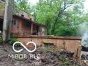 Shows damage between the house and a retaining wall at 8803 S Sleepy Hollow Rd, Waldron, IN 46182