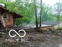 Exterior view showing house with damaged surroundings and detached garage at 8803 S Sleepy Hollow Rd, Waldron, IN 46182