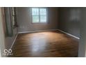 Bright bedroom features hardwood floors, neutral paint, and a window offering natural light at 9024 W Mooresville Rd, Indianapolis, IN 46113