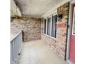 Covered front porch with brick wall, front door, and outdoor plants at 907 Corey Ln, Plainfield, IN 46168