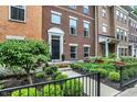 Brick townhome featuring a well-manicured front yard with a black fence at 9508 Oakley Dr, Indianapolis, IN 46260