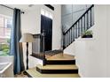 Inviting foyer with hardwood floors, and a staircase with black banister at 9508 Oakley Dr, Indianapolis, IN 46260