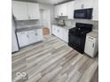 Bright kitchen boasting white cabinets, granite countertops, and updated black appliances at 9526 Burrwood Ct, Indianapolis, IN 46235