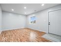 Bright living room featuring hardwood floors, a large window, and a white entry door at 9526 Burrwood Ct, Indianapolis, IN 46235