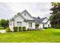Classic brick home boasting a well-maintained lawn, complemented by flowering bushes and greenery at 9678 Winter Way, Zionsville, IN 46077