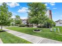 Well-manicured front yard with mature trees and landscaping, enhancing the curb appeal of the home at 10805 Solis Cir, Fishers, IN 46038