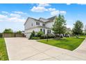 Spacious home with a long driveway, basketball hoop, and a well-kept lawn, and lots of trees at 10805 Solis Cir, Fishers, IN 46038