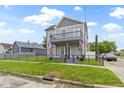 Beautiful two-story home featuring a charming balcony and a well-manicured front lawn at 134 N Elder Ave, Indianapolis, IN 46222