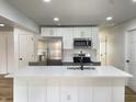 Modern kitchen with stainless steel appliances, white cabinets, island with sink, and stylish backsplash at 1649 N Arsenal Ave, Indianapolis, IN 46218