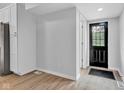 Bright entryway featuring light gray walls, wood-look floors, and a modern black front door at 1805 Center Valley Rd, Martinsville, IN 46151