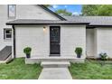 Charming entryway with modern black door, freshly painted white brick, and professional landscaping at 1805 Center Valley Rd, Martinsville, IN 46151