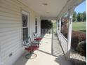 Relaxing covered porch with comfortable seating, perfect for enjoying the outdoor scenery at 2020 N Hickory Blvd, Greenfield, IN 46140