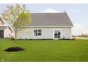Well-maintained backyard with lush grass, a young tree, and a sliding glass door that provides natural light at 278 Evening Bay Ct, Pendleton, IN 46064