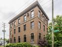 A three-story brick building with ornate details and lush landscaping in a residential area at 3959 Central Ave, Indianapolis, IN 46205