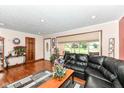 Inviting living room with a black leather sectional, hardwood floors, and a view to the front yard at 4080 Wander Way, Greenwood, IN 46142