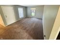 A carpeted bedroom offers a blank canvas with neutral walls, a large window, and ample natural light at 4408 Clovelly Ct, Indianapolis, IN 46254