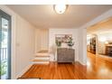 Bright foyer featuring hardwood floors, stairs, and a stylish accent chest with decorative plants at 4491 W 600 N, Anderson, IN 46011