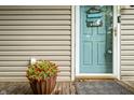 Inviting front door with a 'Welcome to our House' sign, a potted plant, and a gray doormat at 460 W Hinshaw Dr, Nineveh, IN 46164