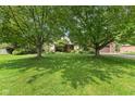 Spacious front yard with mature trees providing ample shade and a well-maintained lawn at 476 Turnberry Ct, Avon, IN 46123