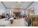 Cozy living room features a brick fireplace, plush carpeting, and comfortable seating at 476 Turnberry Ct, Avon, IN 46123