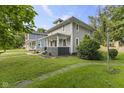A well-maintained home with a covered front porch, green lawn, and neat landscaping, great curb appeal at 4836 Winthrop Ave, Indianapolis, IN 46205