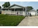 Inviting home with a spacious porch and a detached garage, offering both comfort and convenience at 4908 Elmhurst Dr, Indianapolis, IN 46226