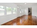 Bright living room with gleaming hardwood floors and plenty of natural light from multiple windows at 517 N Leland St, Fortville, IN 46040